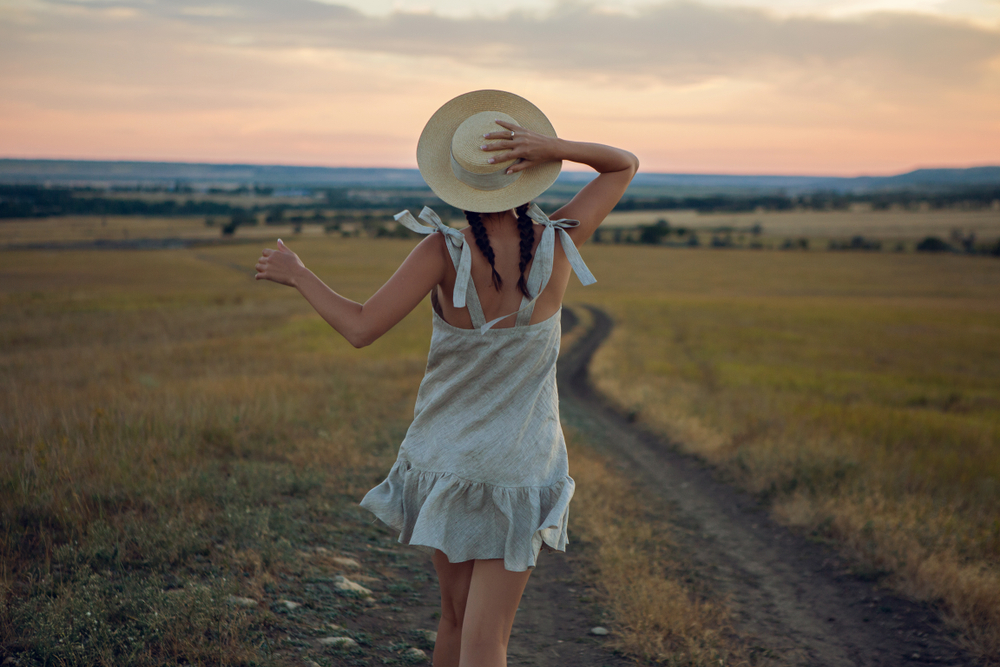 Girl running through the fields in summer