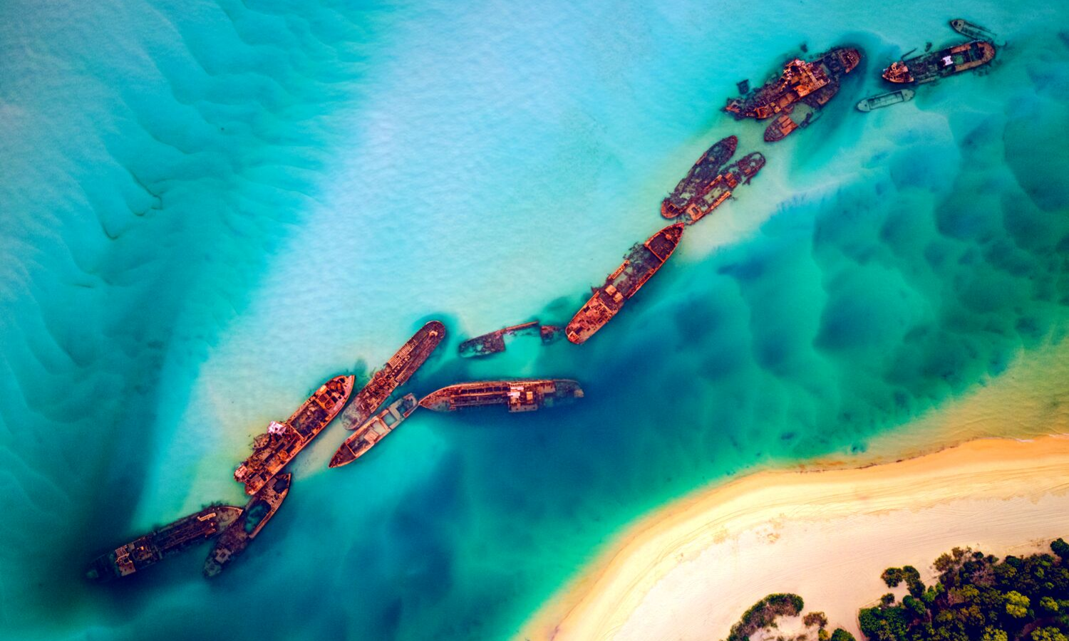 Aerial shot of the Tangalooma wrecks. This is a line of rusting wrecks just off the shore line. 