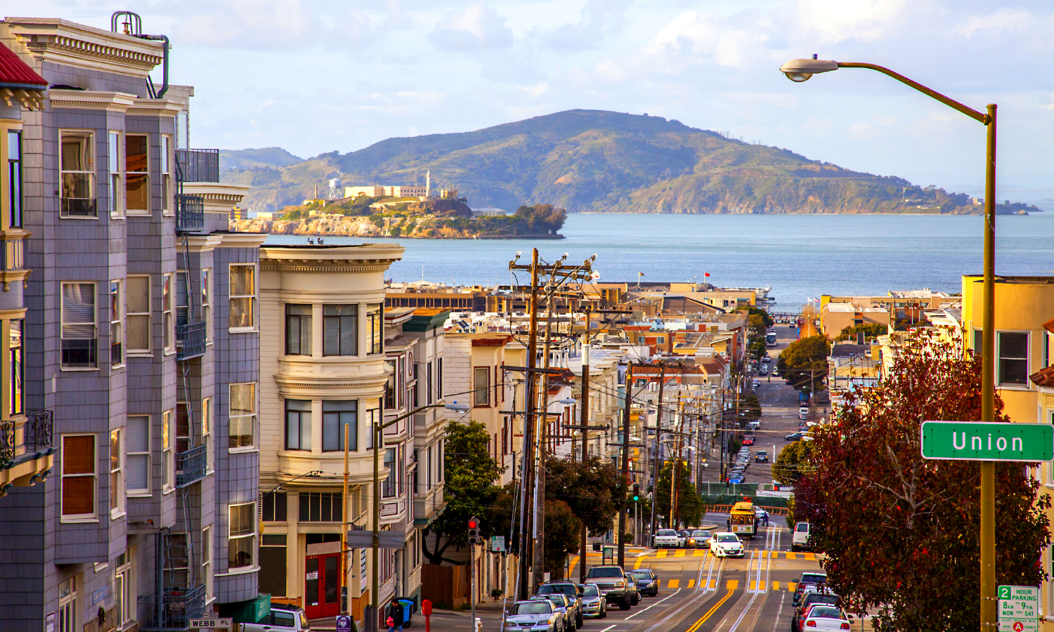 Picture of a San Francisco street with Alcatraz island in the background. 