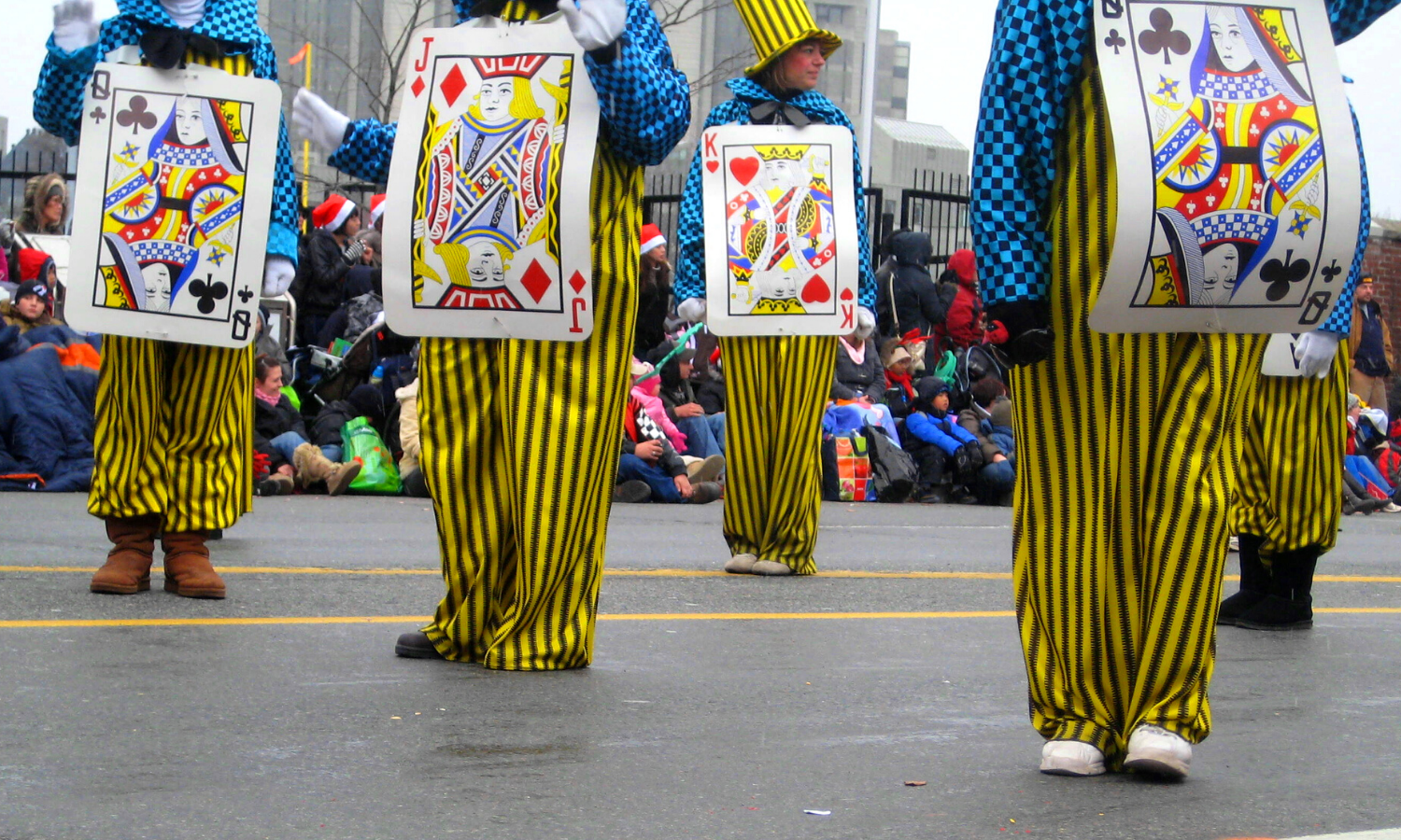 A picture of people dressed up as playing cards. They are all wearing yellow stripey trousers and blue checked shirts. 