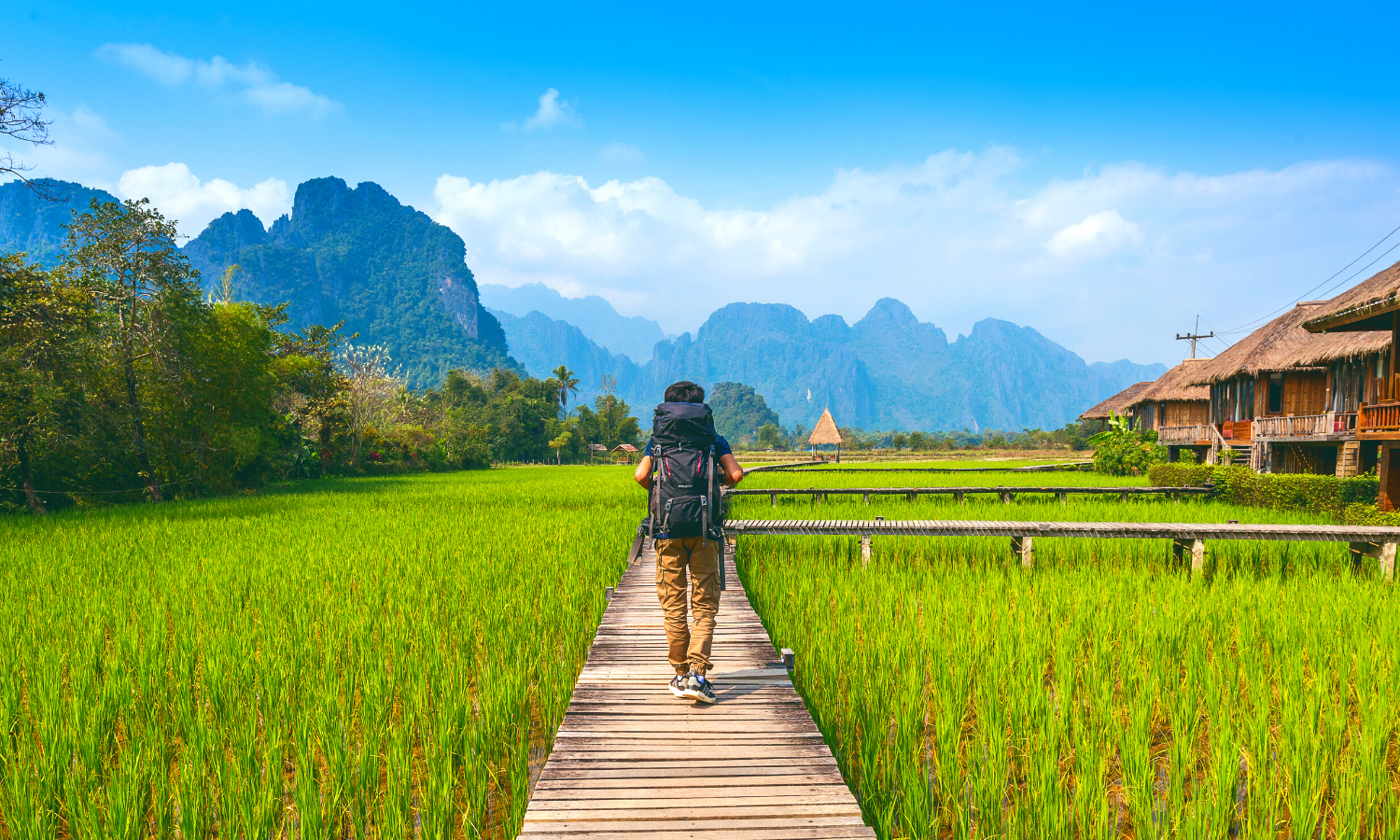 Backpacker walking towards mountains of Laos